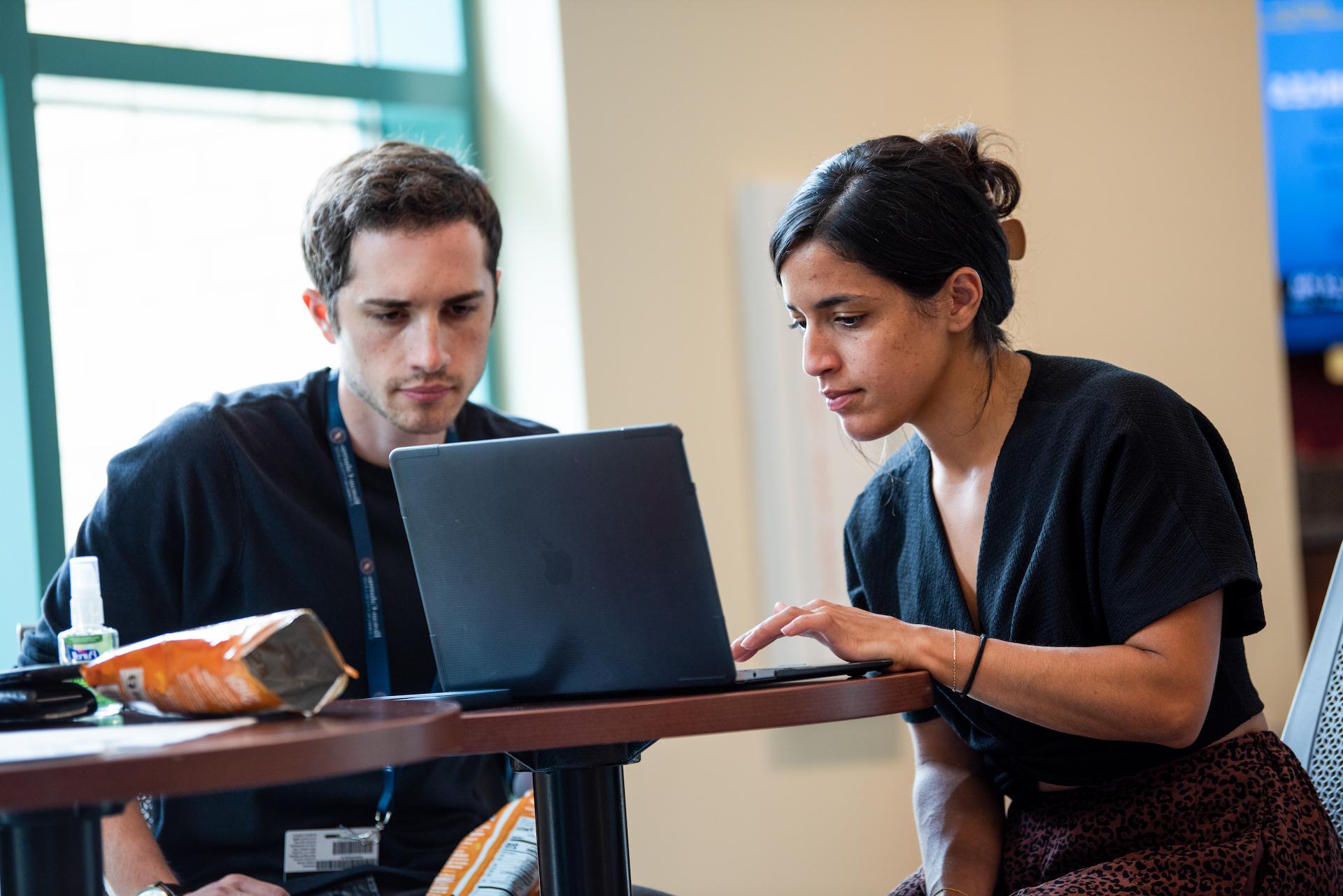 Students collaborating on laptop in student center